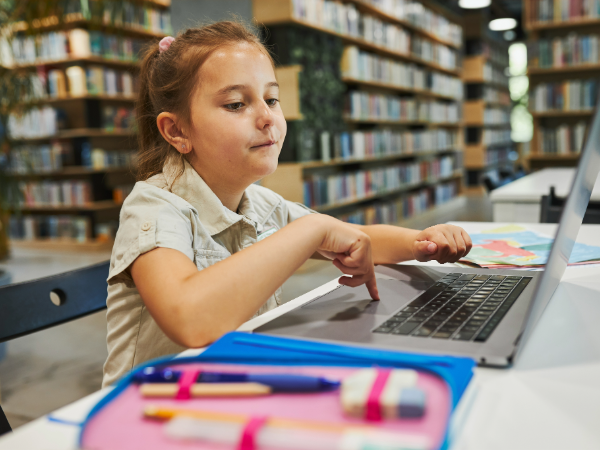 primary-school-student-in-library-on-laptop-using-reading-cloud